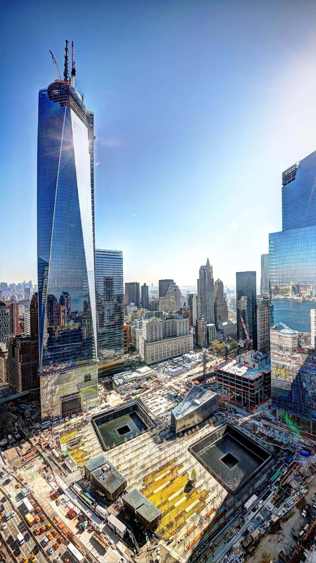 建設中的自由塔天際線 壁紙 — 從高空俯瞰世界貿易中心一號大樓在晴朗藍天下從繁忙的建築工地中拔地而起。