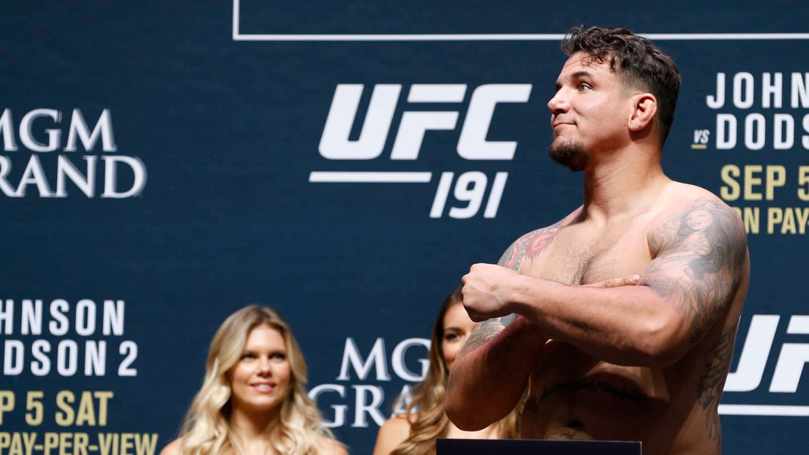 UFC拳手在稱重活動現場，身後有宣傳橫幅