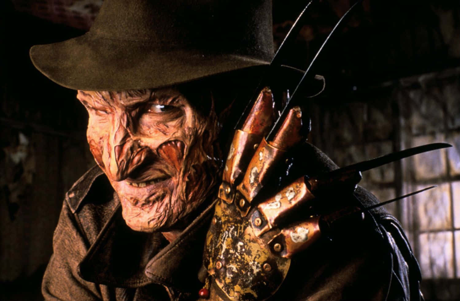 Freddy Krueger 桌布 壁紙 — 弗雷迪·克魯格的特寫，他燒傷的臉和刀片手套在昏暗的房間裡。