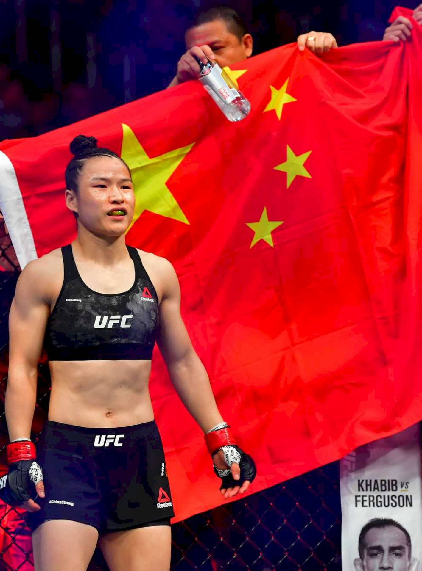 UFC拳手在活動中於中國國旗前手持拳套。