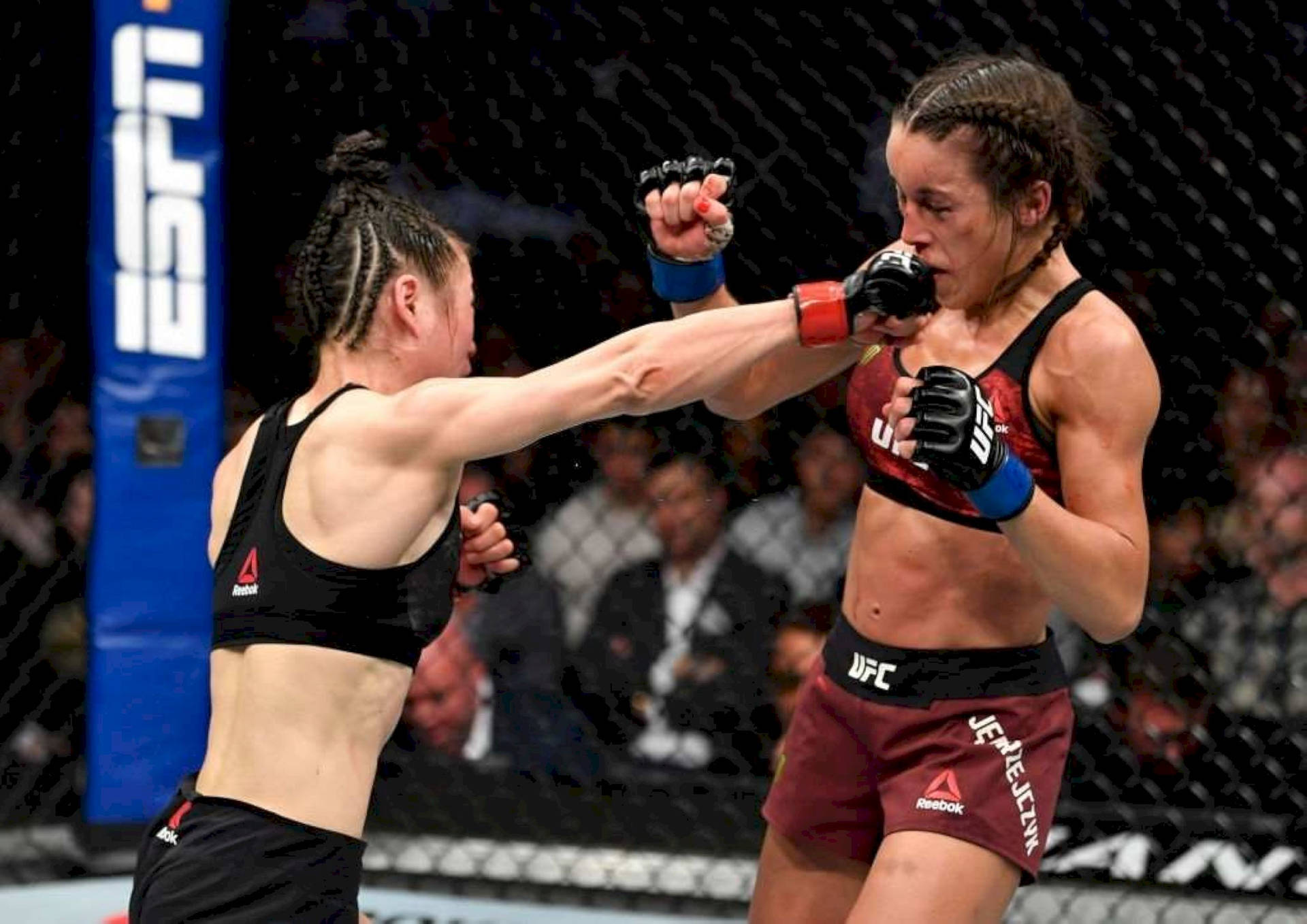 兩名女性MMA拳手在八角籠中交換拳擊。
