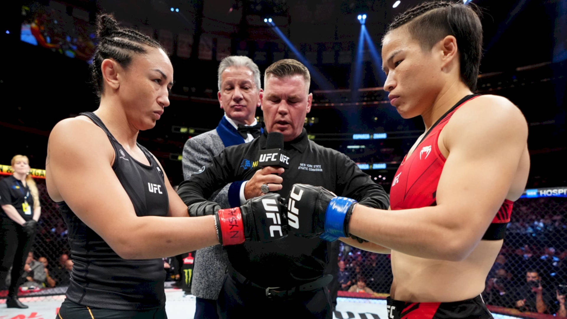 兩名女子MMA拳手在場館燈光下於UFC比賽前碰拳套。