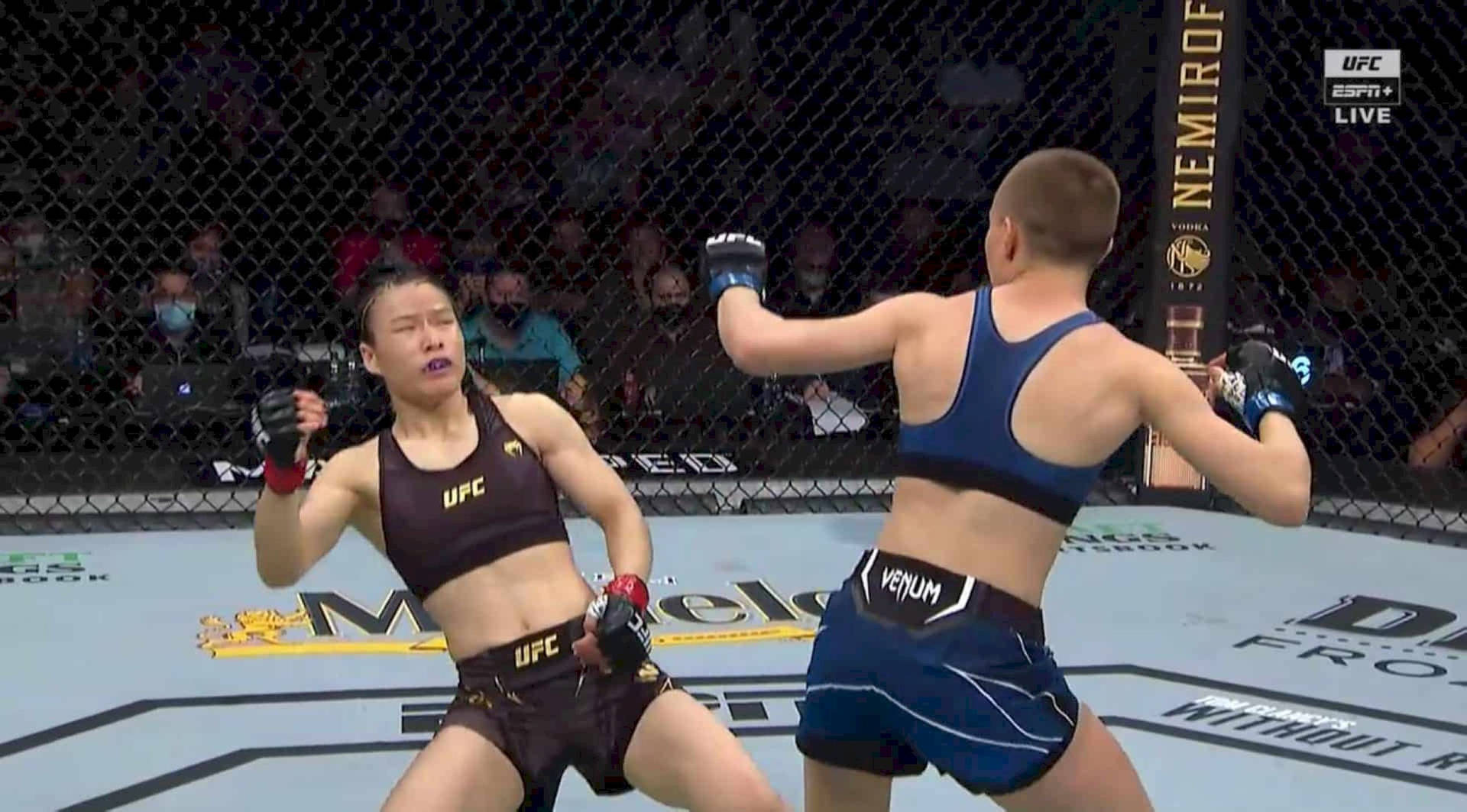 張偉利閃避羅斯·納馬朱納斯拳擊 壁紙 — 兩名女性MMA拳手在八角籠中交鋒，其中一人打出強力一拳，另一人則準備承受衝擊。