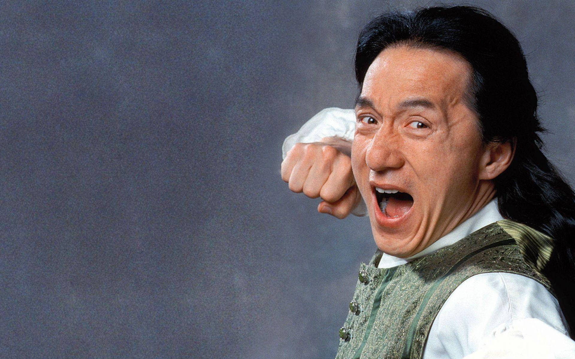 張學友怒吼壁紙 壁紙 — 成龍在煙霧彌漫的灰色背景下，握緊拳頭、表情強烈的動態肖像。