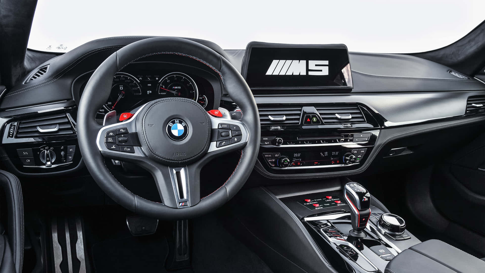 BMW M5汽車內飾，黑色皮革和紅色點綴。
