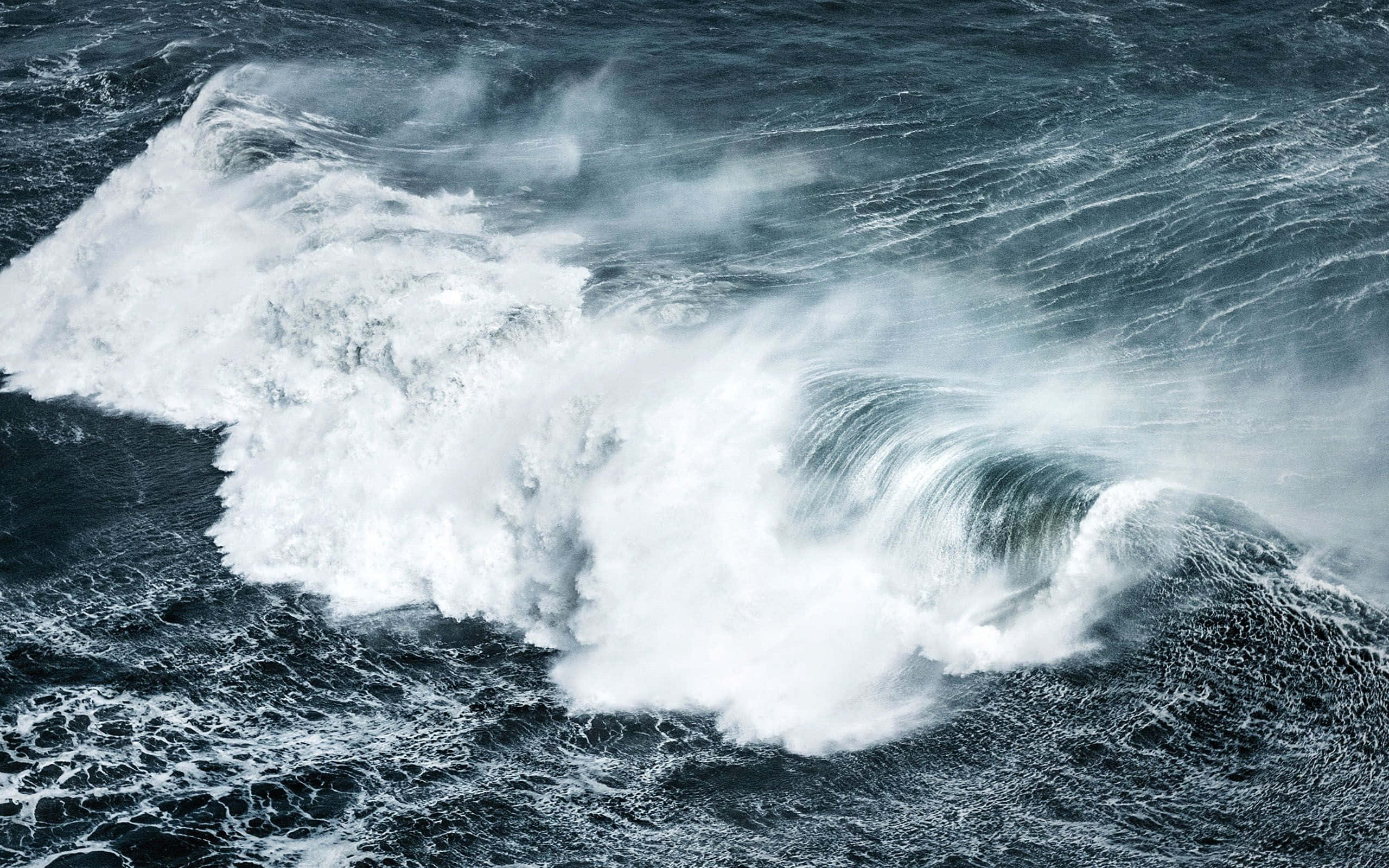 海浪 桌布 壁紙 — 強勁的海浪拍打著白色泡沫，撞向黑暗翻滾的海水，呈現戲劇性的空中視角。