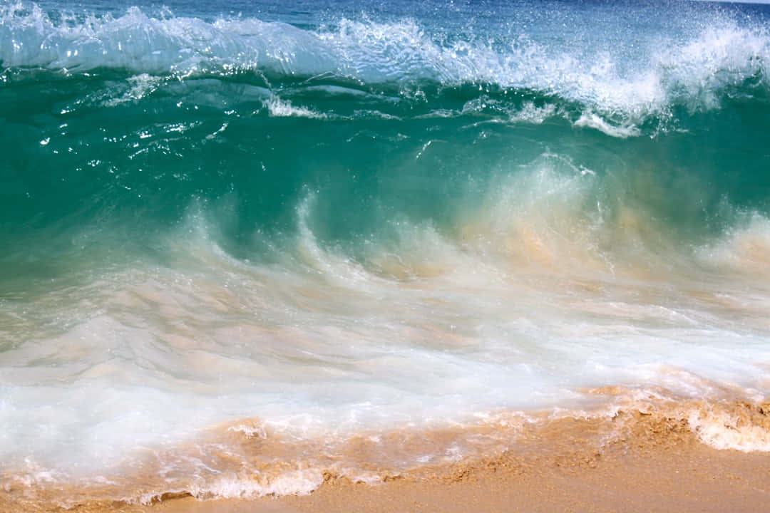 Beach Waves 桌布 壁紙 — 強勁的碧綠色海浪在明亮的日光下拍打金色沙灘，濺起白色泡沫。
