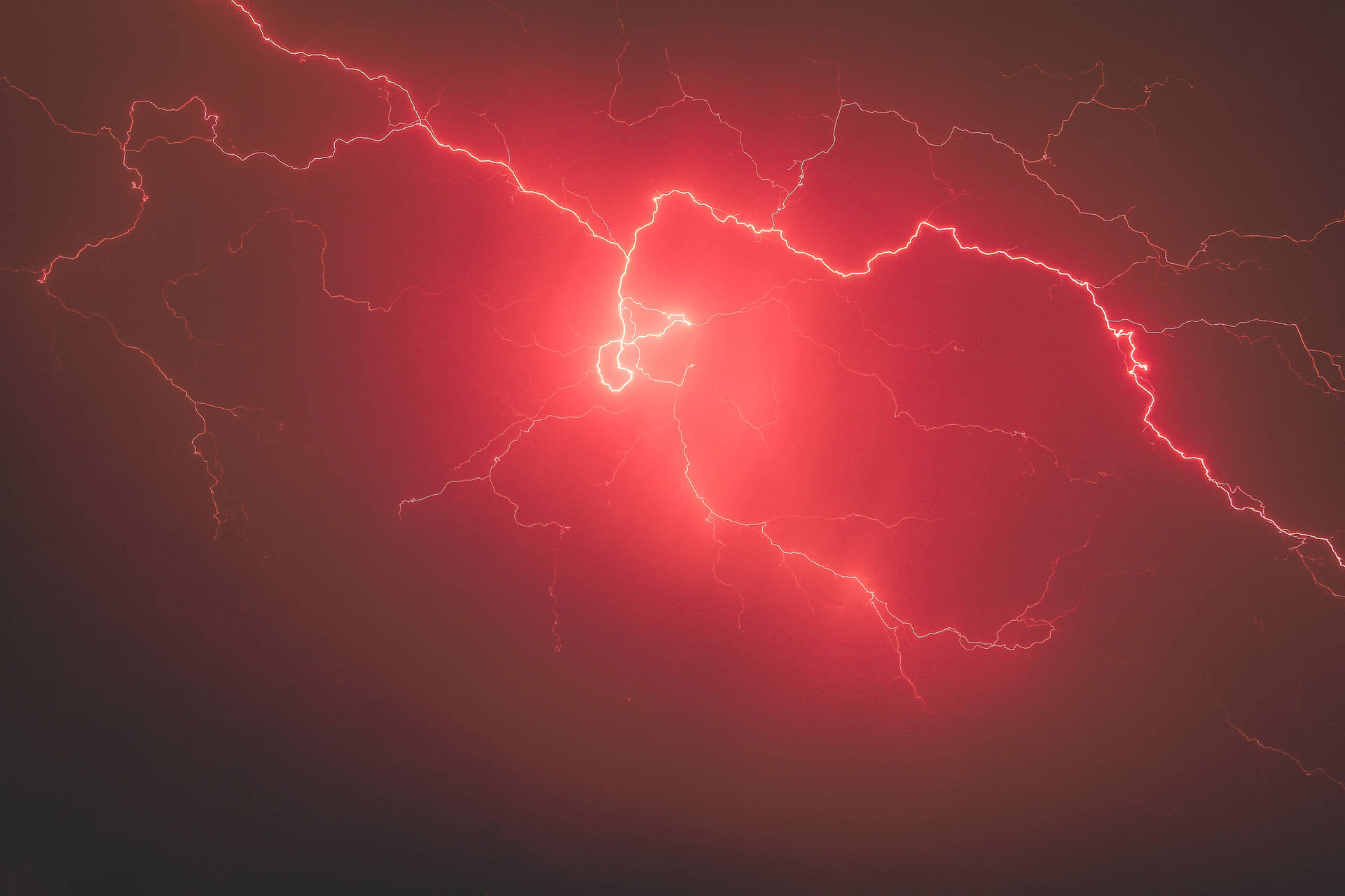 紅色閃電以分支的電能照亮黑暗的暴風雨天空。