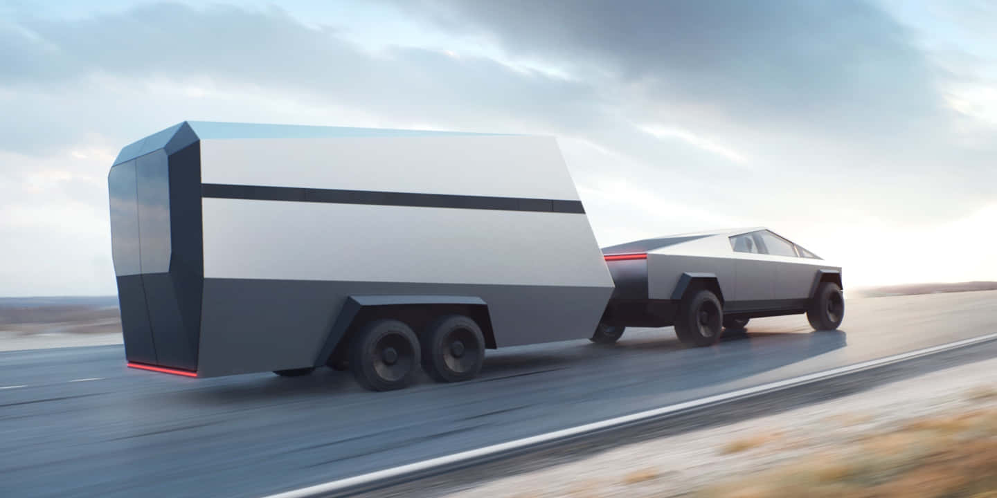 未來感十足的銀色 Tesla Cybertruck 在沙漠公路上拖著一個相配的拖車。