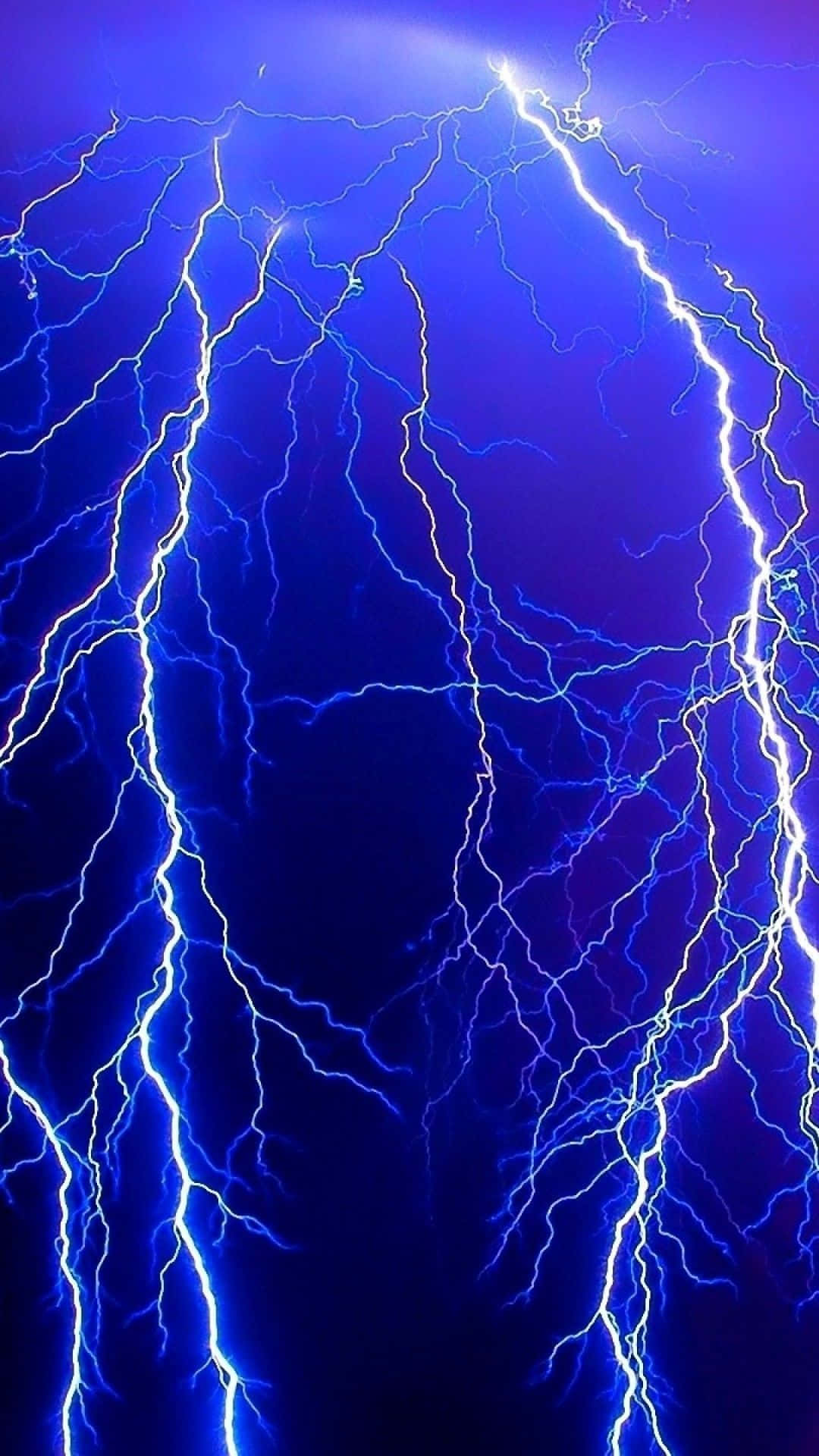 Thunderstorm 桌布 壁紙 — 強烈的藍色閃電在深紫色暴風雨天空中噼啪作響，形成戲劇性的垂直構圖。