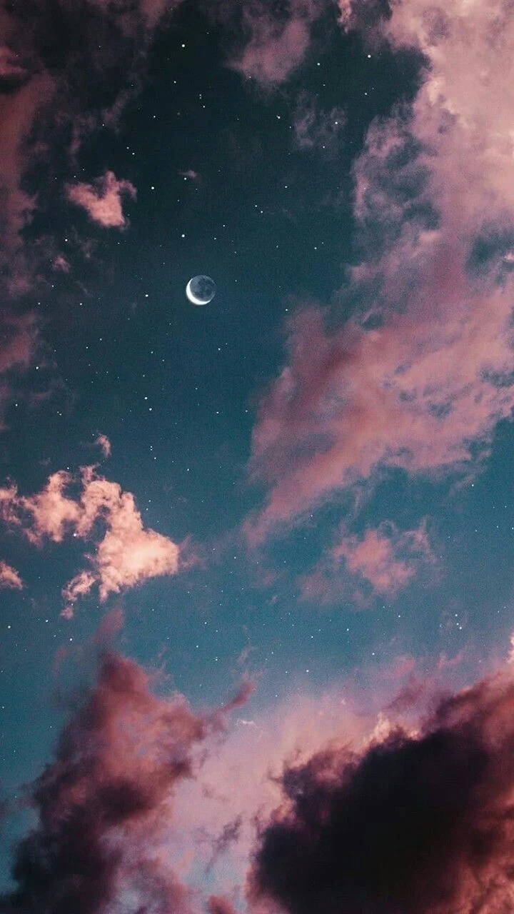 彎月夜空手機壁紙 壁紙 — 一彎新月在繁星點點的夜空中閃耀，被柔和的粉紅色和紫色雲彩環繞。