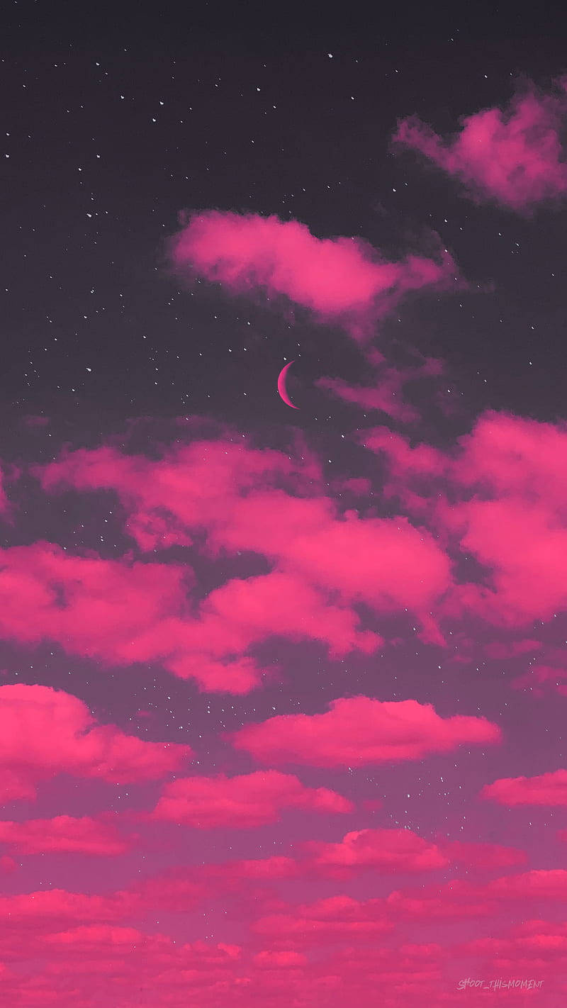 繁星夜空中的粉紅雲彩和彎月
