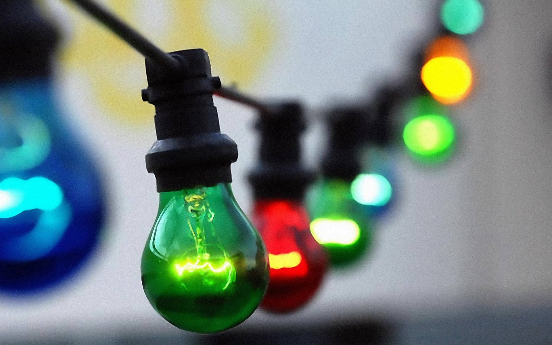 一串彩色發光燈泡，綠色對焦。