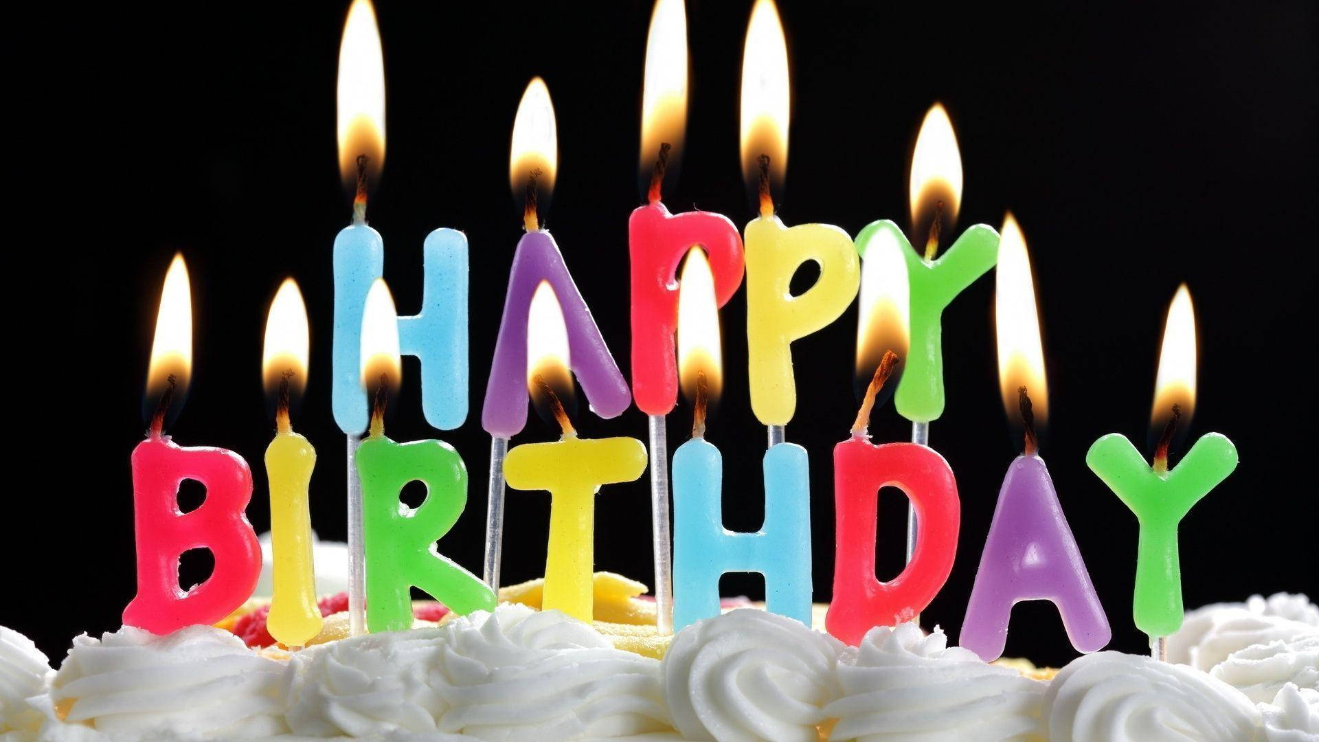 生日蛋糕上點燃了色彩繽紛的蠟燭，拼出 happy birthday。