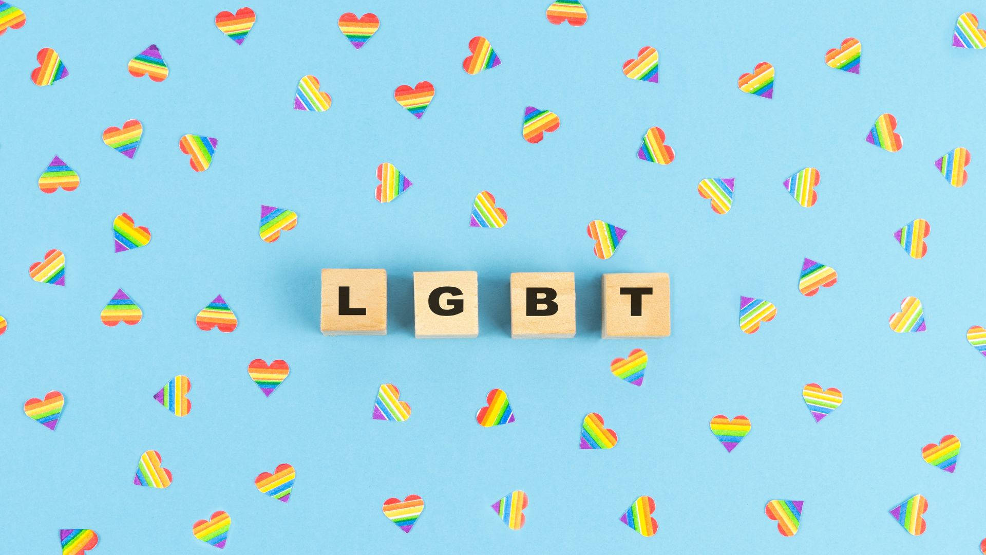 喺藍色背景上，拼出LGBT嘅木塊被彩虹心形包圍。