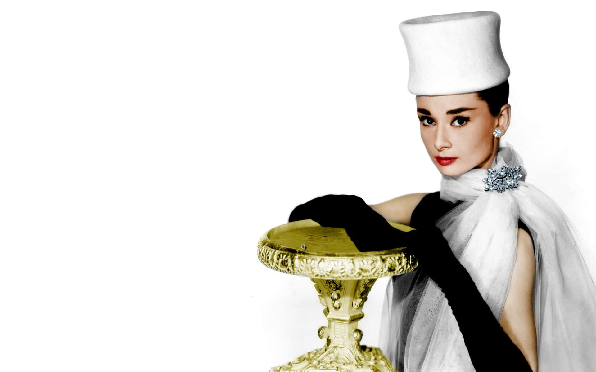 柯德莉·夏萍身穿黑白禮服，戴白色帽子，金色底座