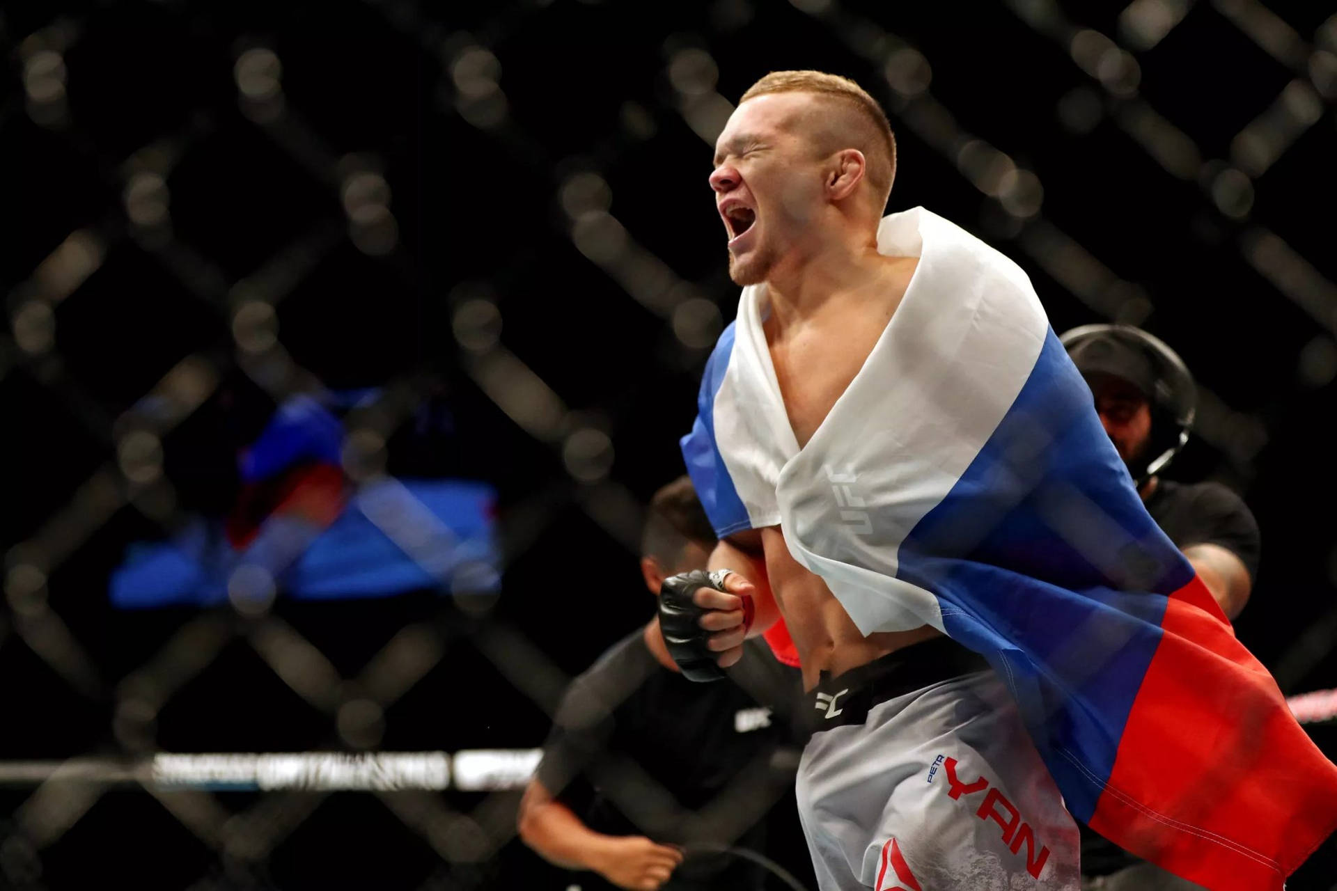 MMA拳手披著俄羅斯國旗在八角籠中慶祝勝利。
