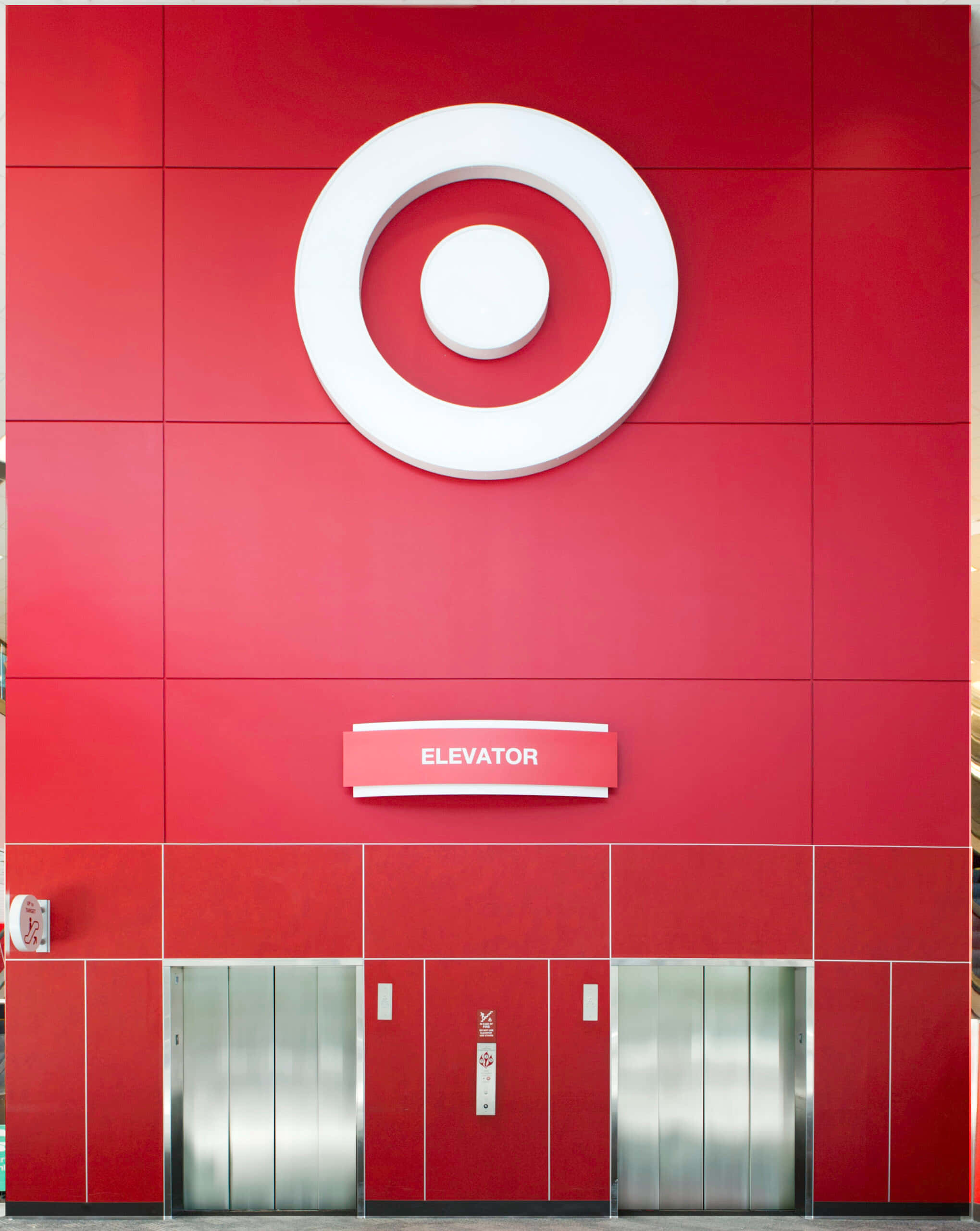 《往上走嗎？》 壁紙 — 一間大膽的紅色Target商店外牆，在時尚的電梯入口上方有一個大型白色靶心標誌。