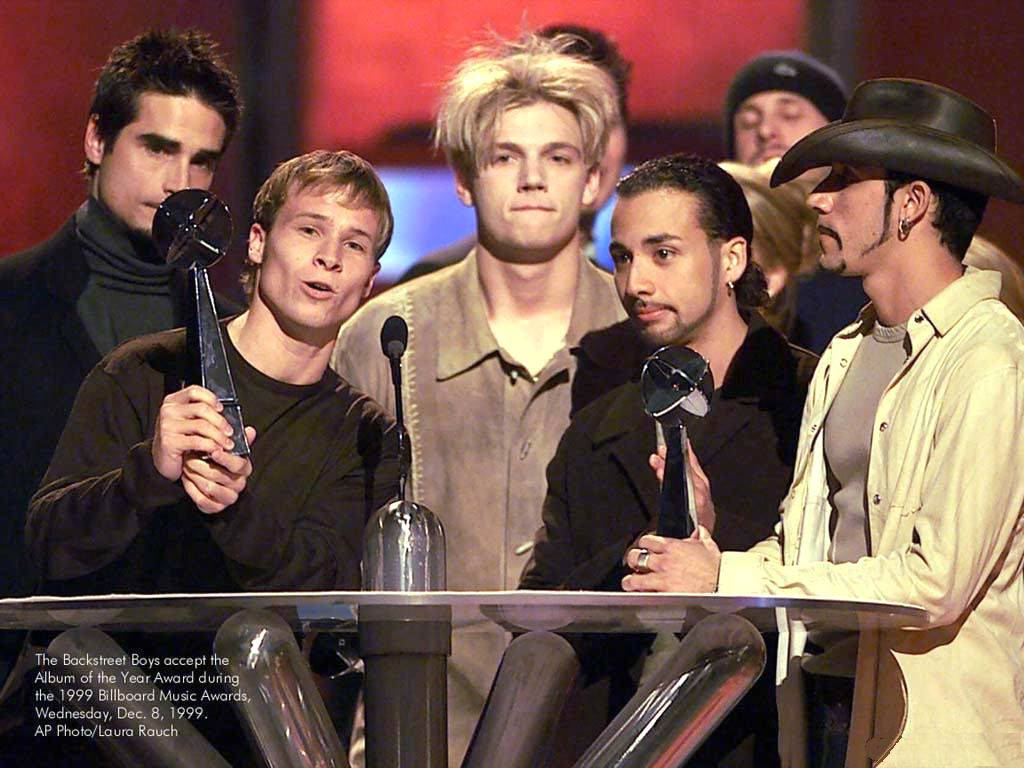 Backstreet Boys 在舞台上手持獎盃領取音樂獎項。