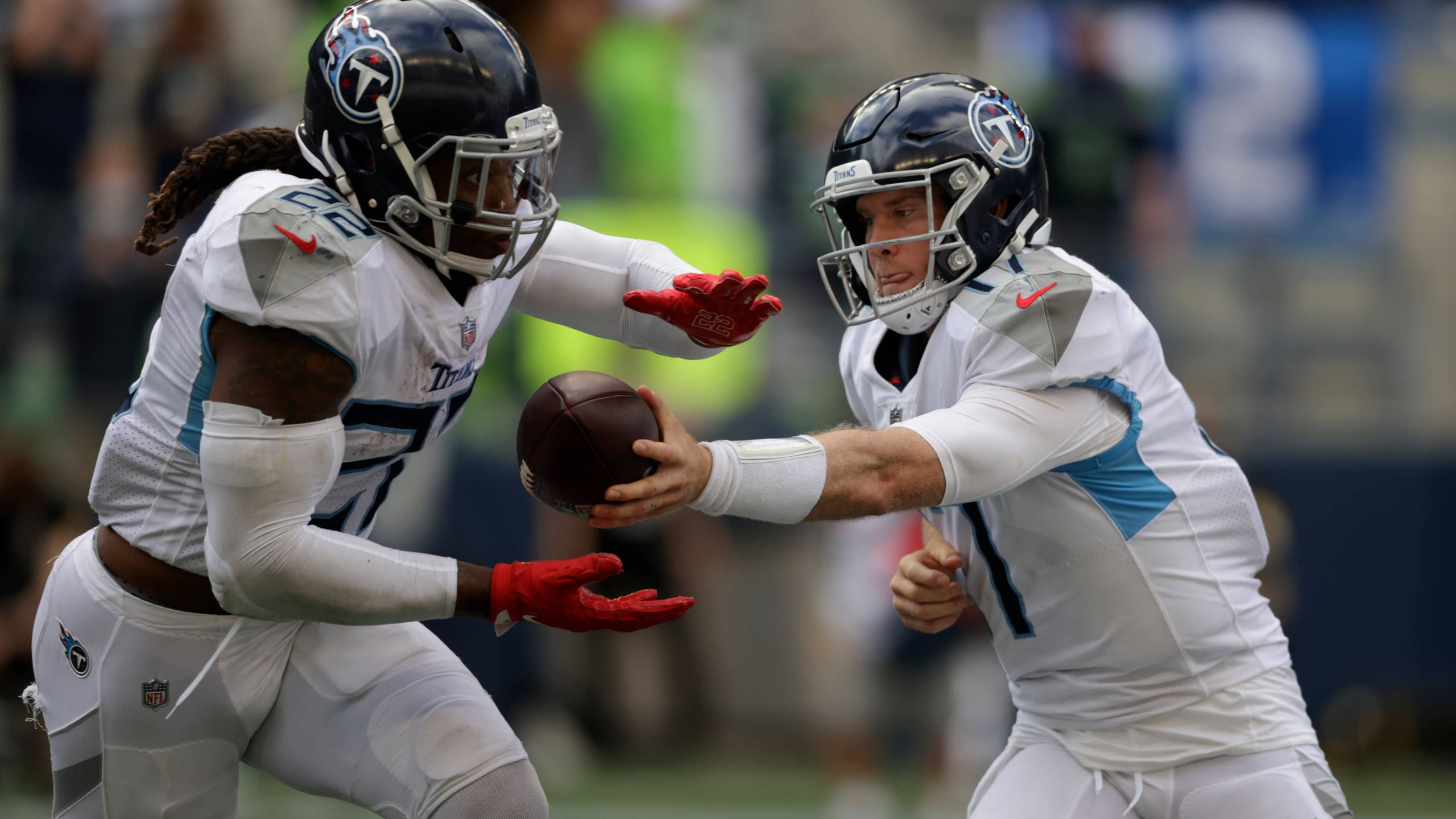 得分製造者德里克·亨利 壁紙 — 田納西泰坦隊的四分衛在激烈的NFL比賽中將橄欖球傳給隊友。