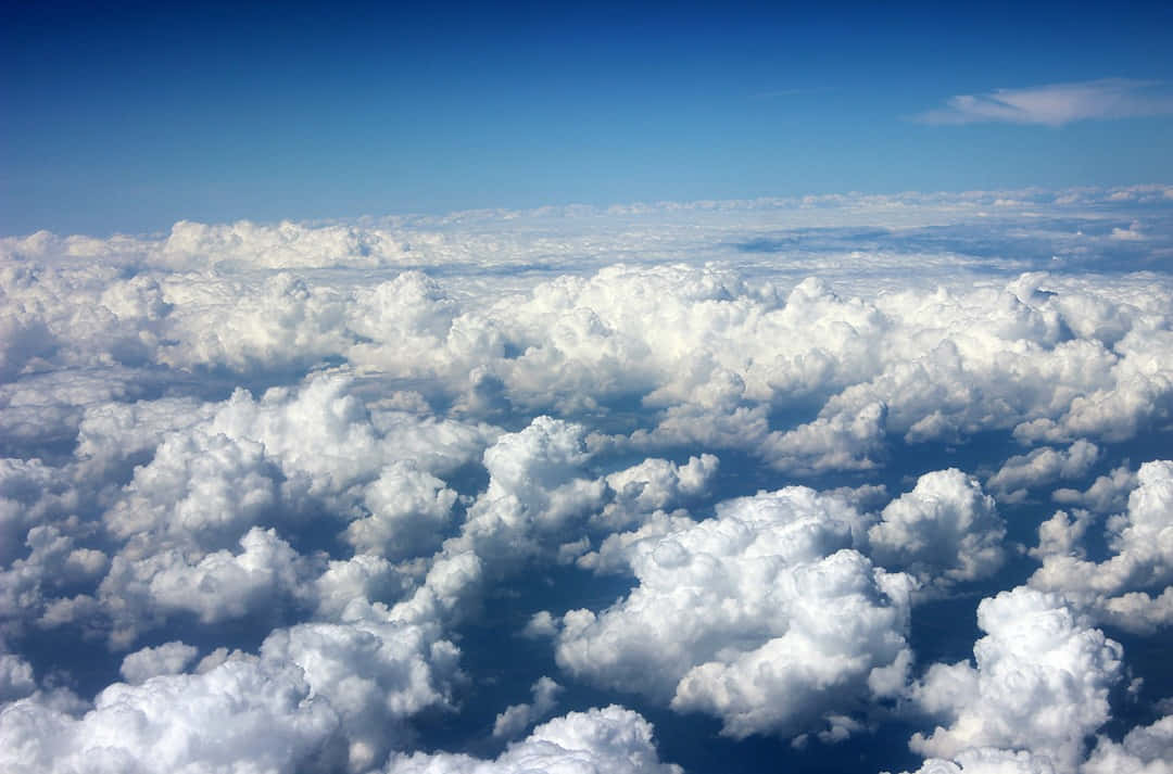 Cloud Aesthetic 桌布 壁紙 — 從上方俯瞰，蓬鬆的白雲在清澈的藍天下無盡延伸的航拍視角。