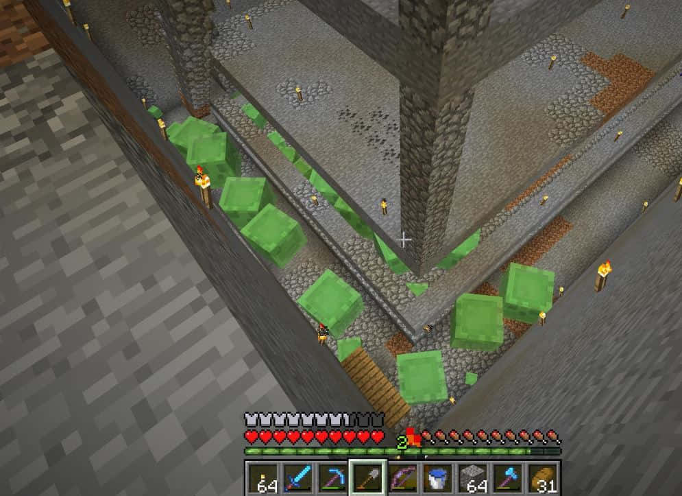 Minecraft Slime Farming 桌布 壁紙 — 從上方俯瞰Minecraft玩家在石結構中挖掘綠色方塊，火炬和生命條可見。