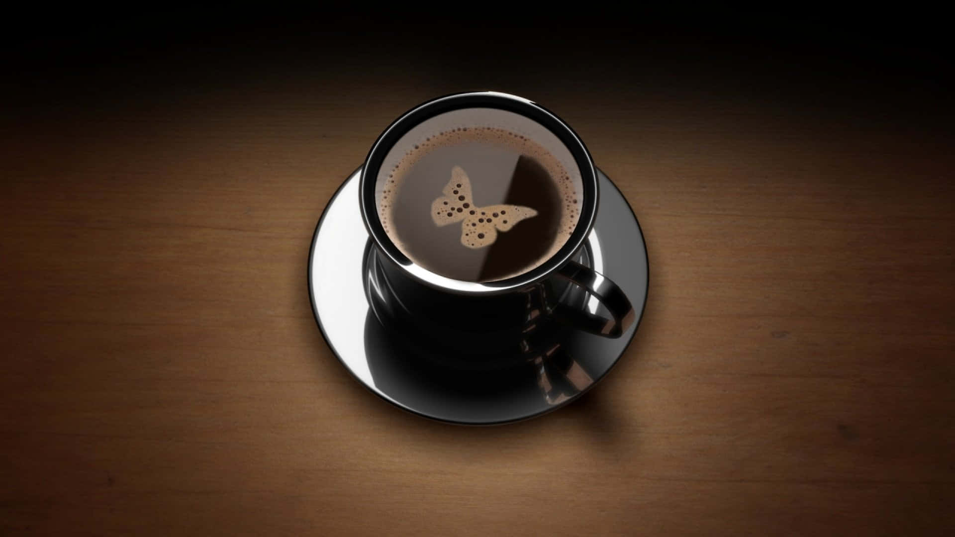 Black Coffee 桌布 壁紙 — 從上方俯瞰一個黑色咖啡杯，杯上有蝴蝶形狀的泡沫圖案，放在木桌上。