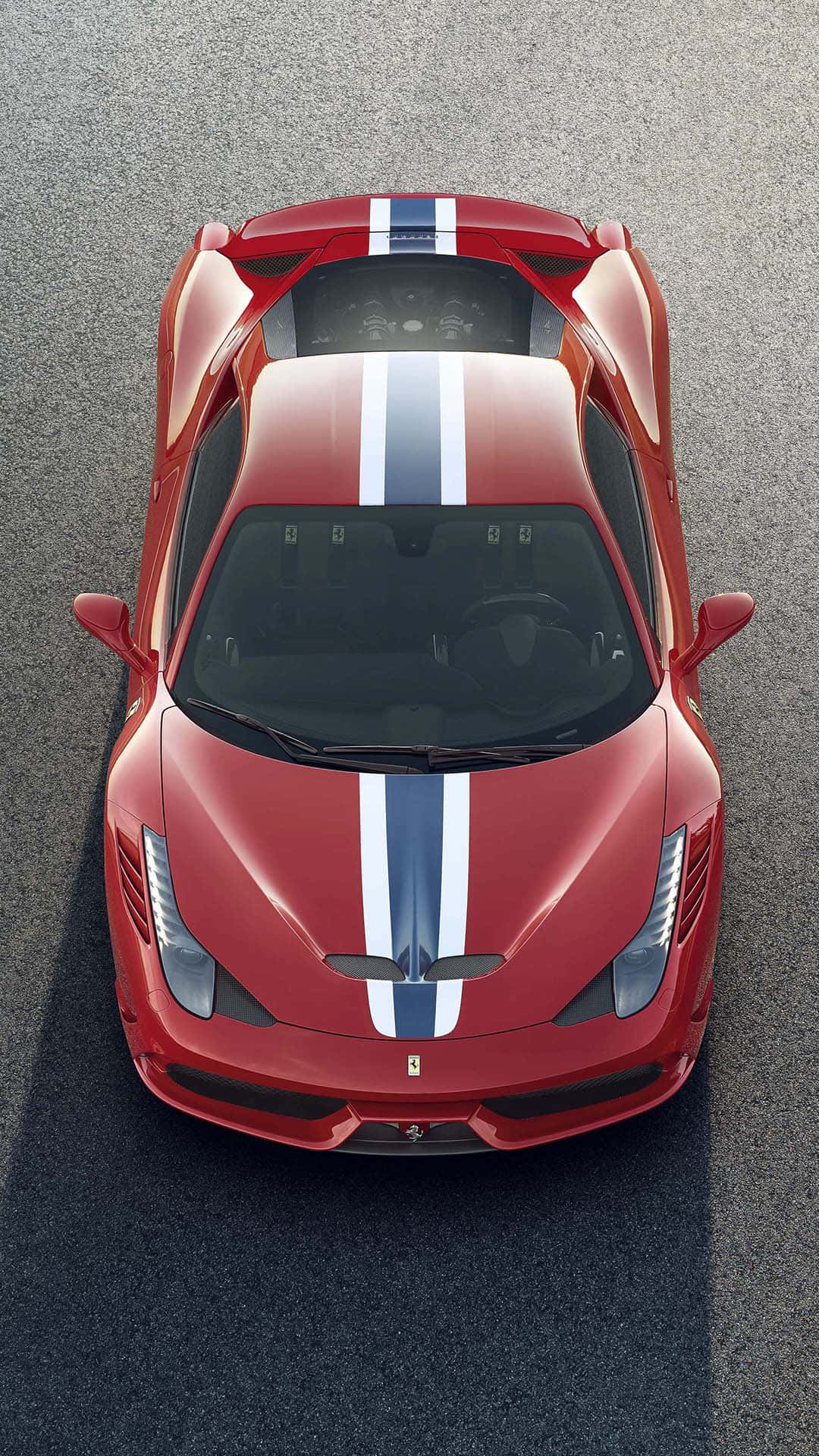 Ferrari 458 Speciale 桌布 壁紙 — 從上方俯瞰一輛紅色法拉利跑車，車身有藍色和白色賽車條紋，停在灰色瀝青路面上。