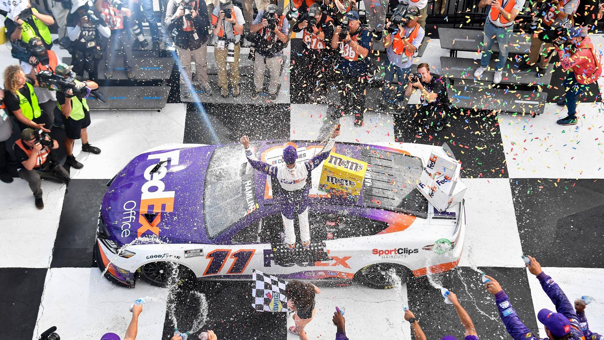 NASCAR車手在格子旗終點線用五彩紙屑和香檳慶祝勝利。