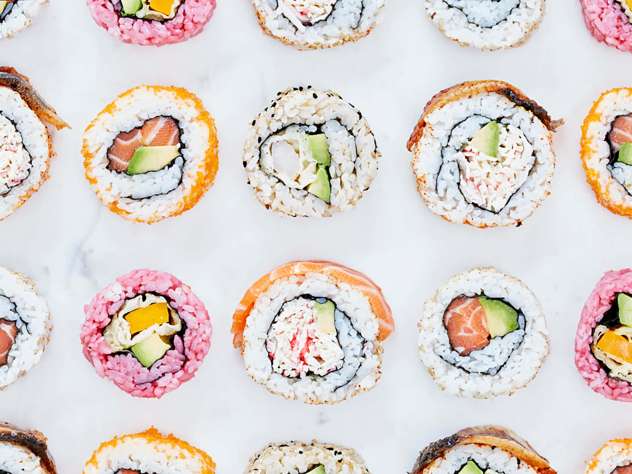 Sushi 桌布 壁紙 — 從上方俯瞰各種壽司卷整齊排列在白色大理石表面上。