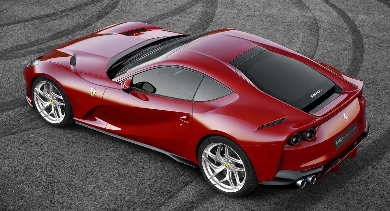 Ferrari 812 Superfast 桌布 壁紙 — 從上方俯瞰賽道上帶有輪胎痕的亮紅色法拉利跑車。