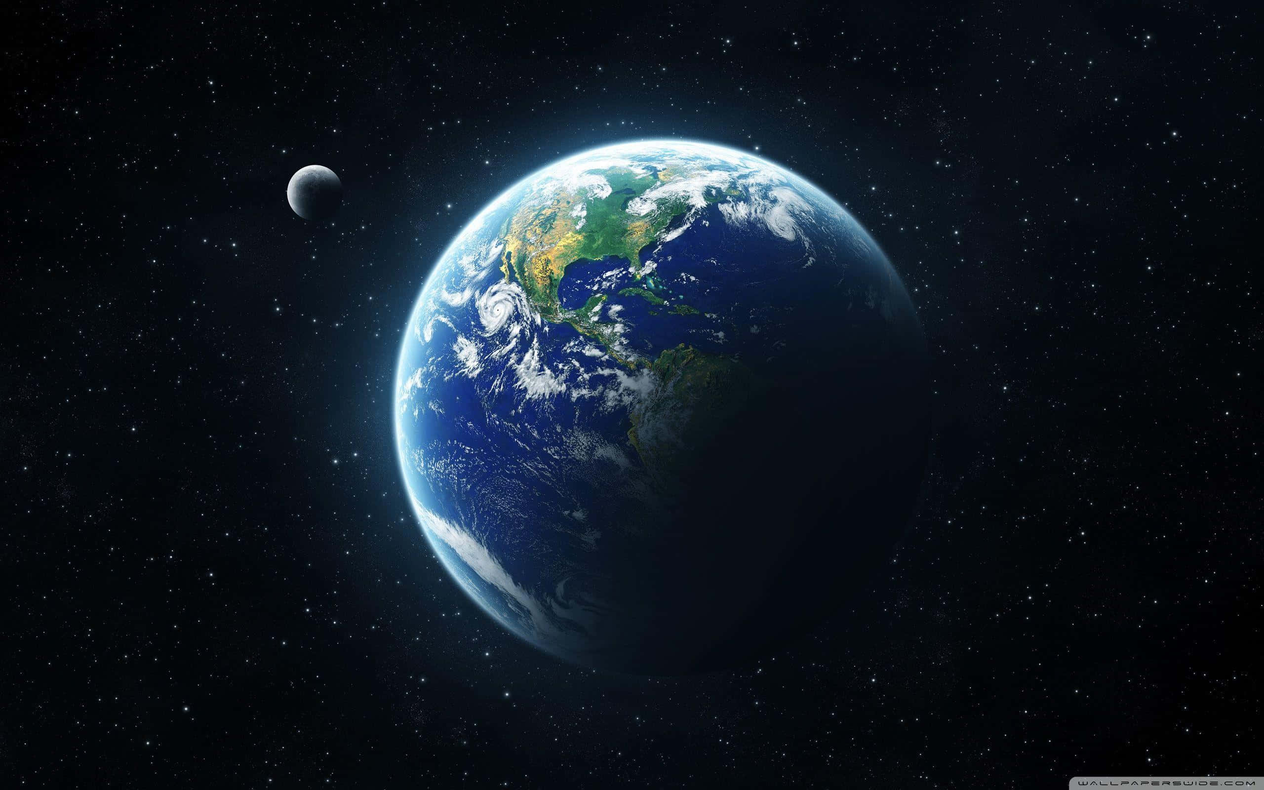從外太空拍攝的地球壯麗景色 壁紙 — 地球在太空中發出藍色和綠色的光芒，周圍有月球和星星。