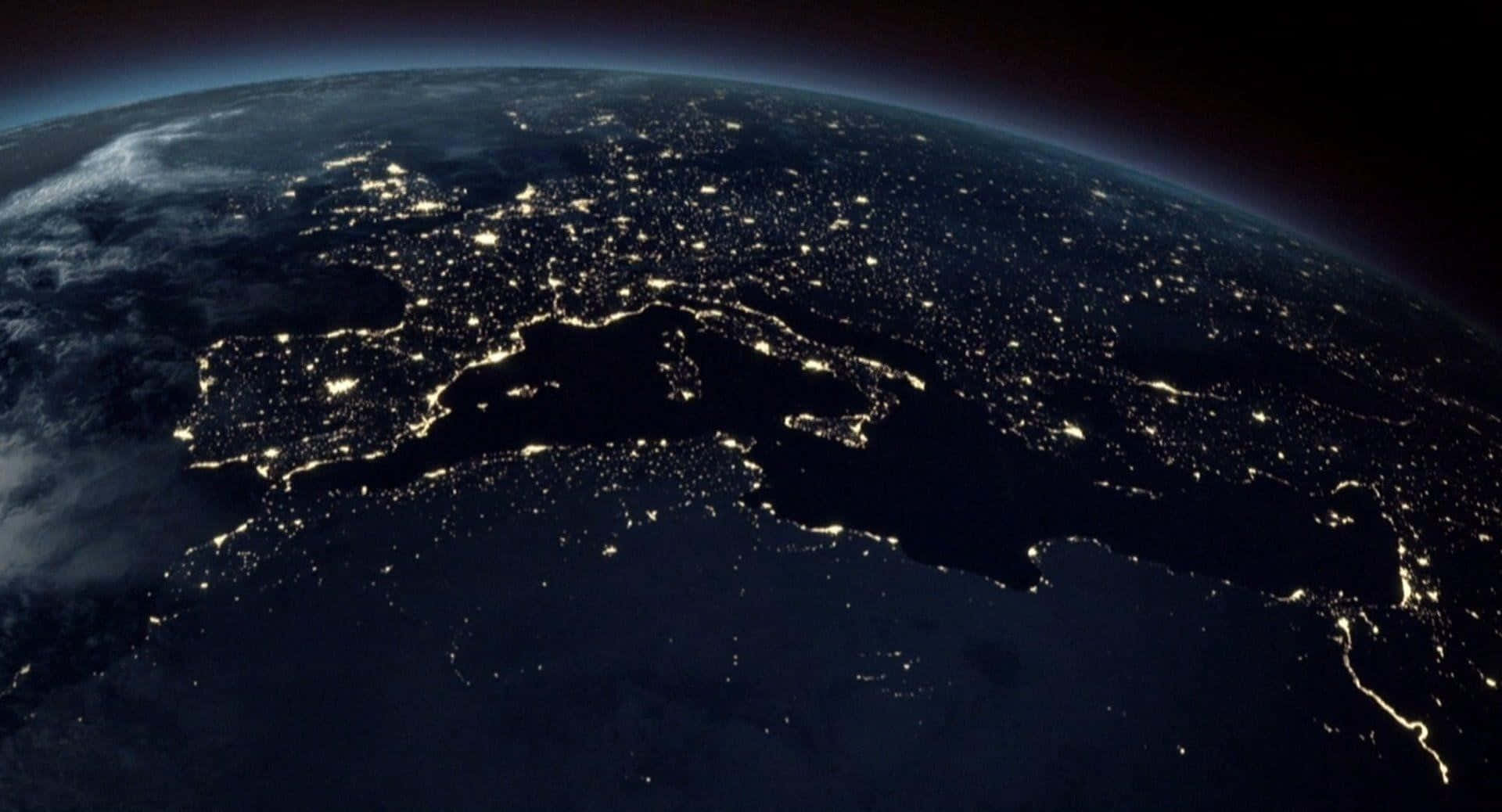 Satellite 桌布 壁紙 — 從太空俯瞰地球的壯麗夜景，展現大陸上閃爍的城市燈光，映襯著黑暗的海洋。