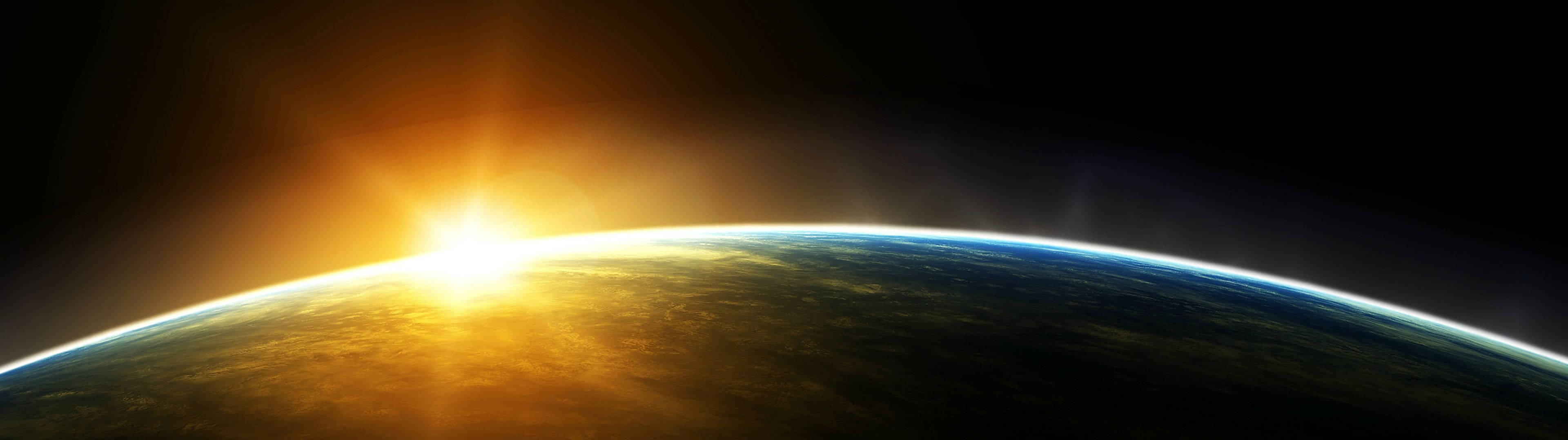 地球 桌布 壁紙 — 從太空俯瞰地球的壯麗景色，太陽從彎曲的地平線升起，將金色光芒灑在雲層和海洋上。