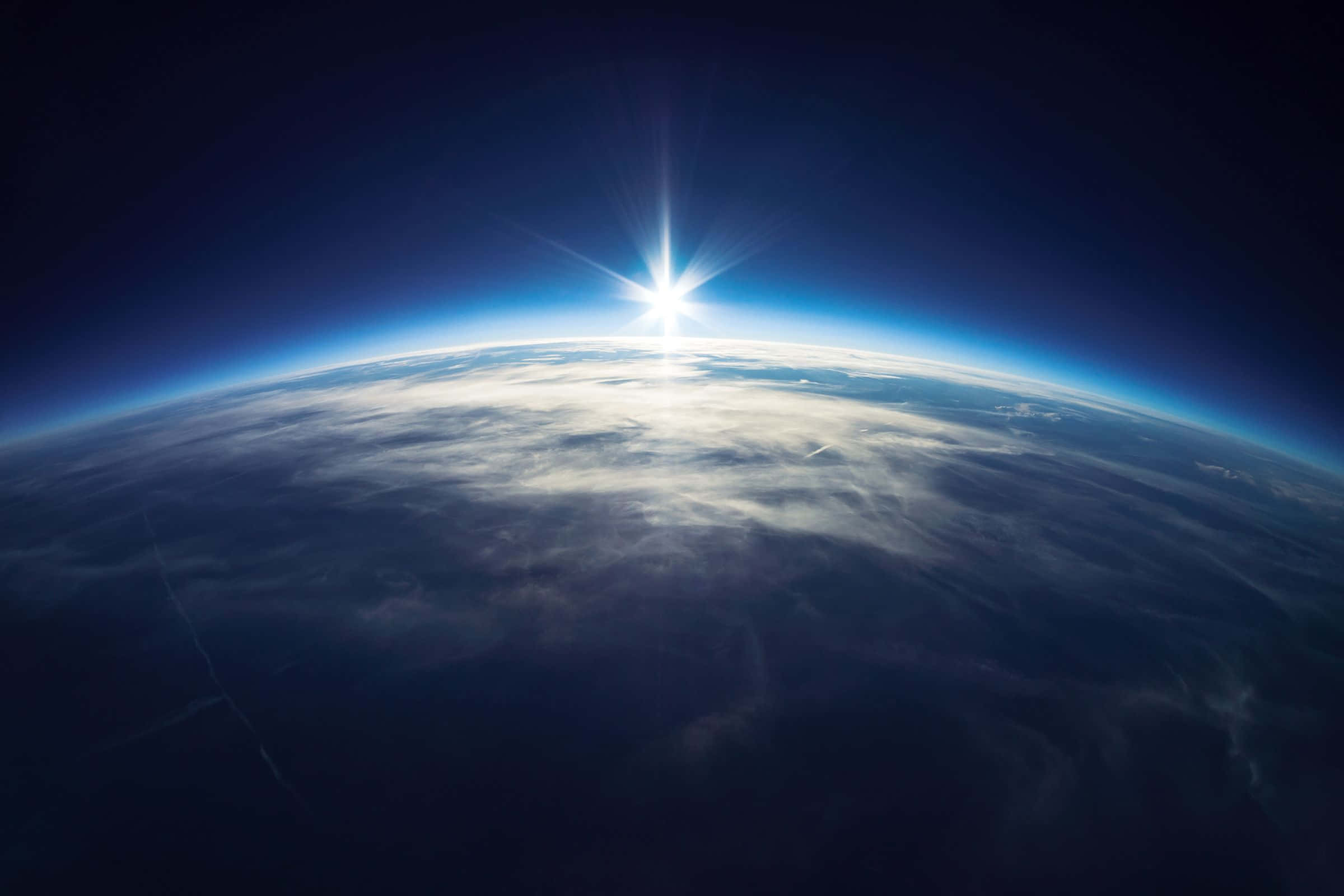 Atmosphere 桌布 壁紙 — 從太空看地球上的日出，發光的地平線和下方的雲層。