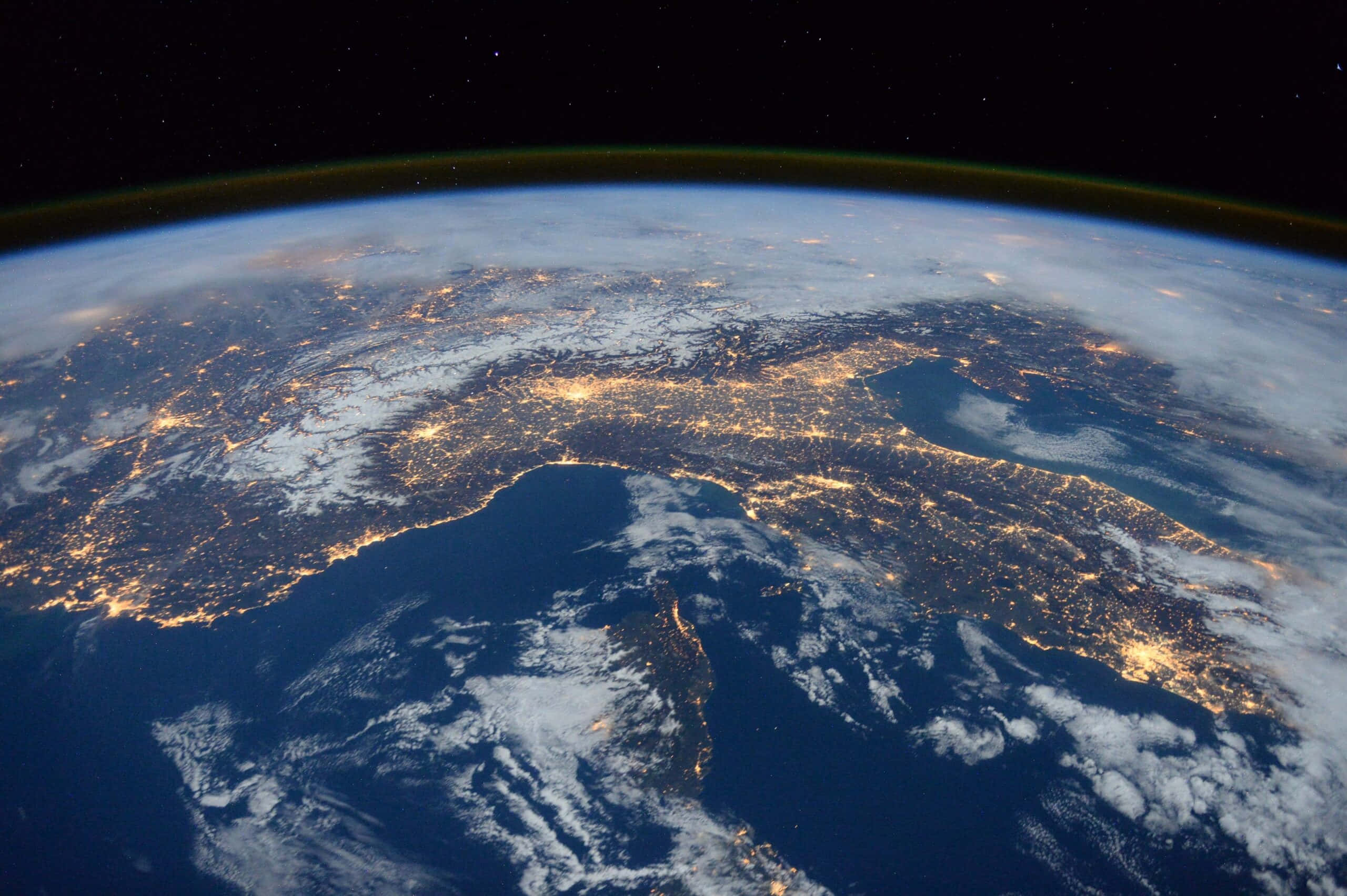 World 桌布 壁紙 — 從太空觀看夜晚的地球，在星空下，各大洲和海洋上閃爍著城市的燈光。