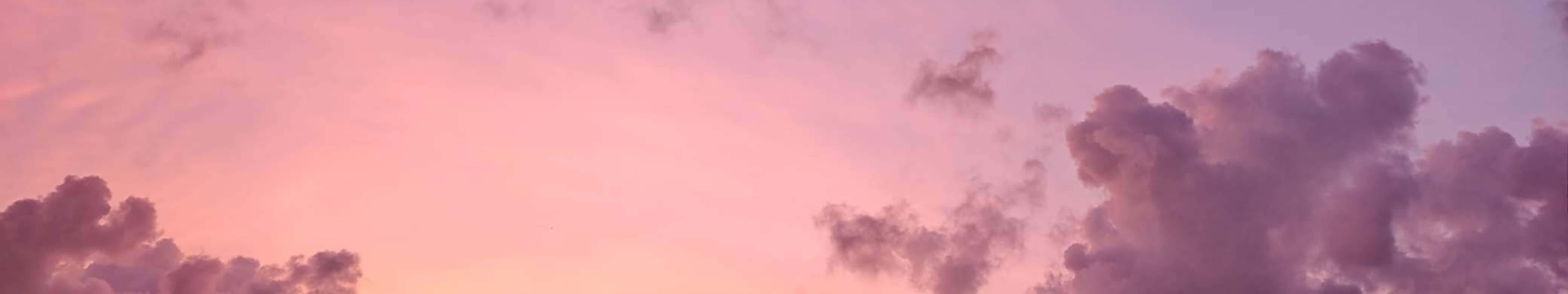 粉紅色和紫色雲朵在寧靜的暮色天空中飄移。