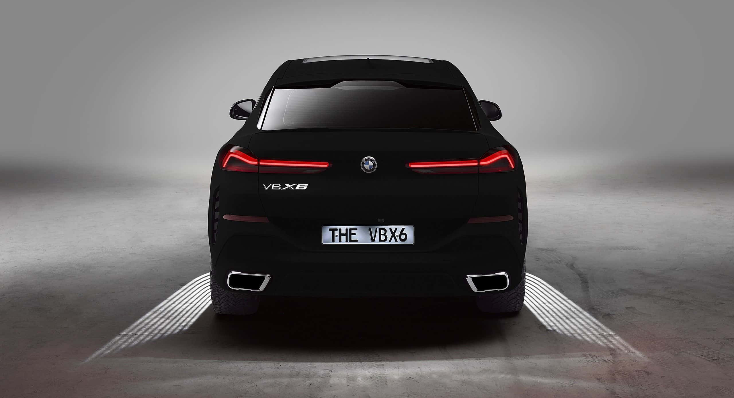 Vantablack 桌布 壁紙 — 從後方觀看的時尚黑色BMW V8X6轎車，帶有發光的紅色尾燈和照明地面圖案，在簡約的攝影棚環境中。