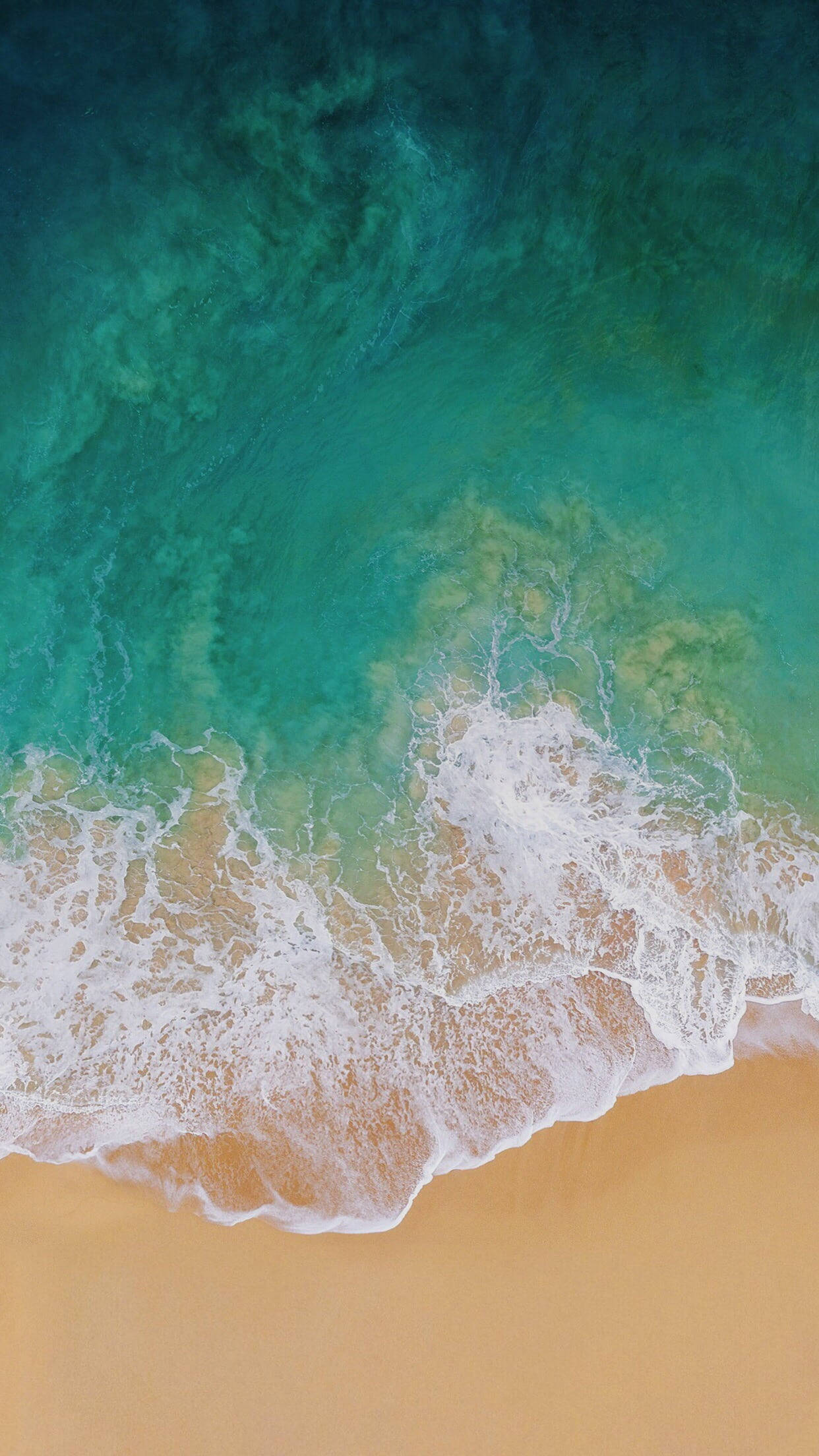 iPhone 桌布 壁紙 — 從空中俯瞰，在寧靜的海岸場景中，碧綠的海浪拍打著金色的沙灘。