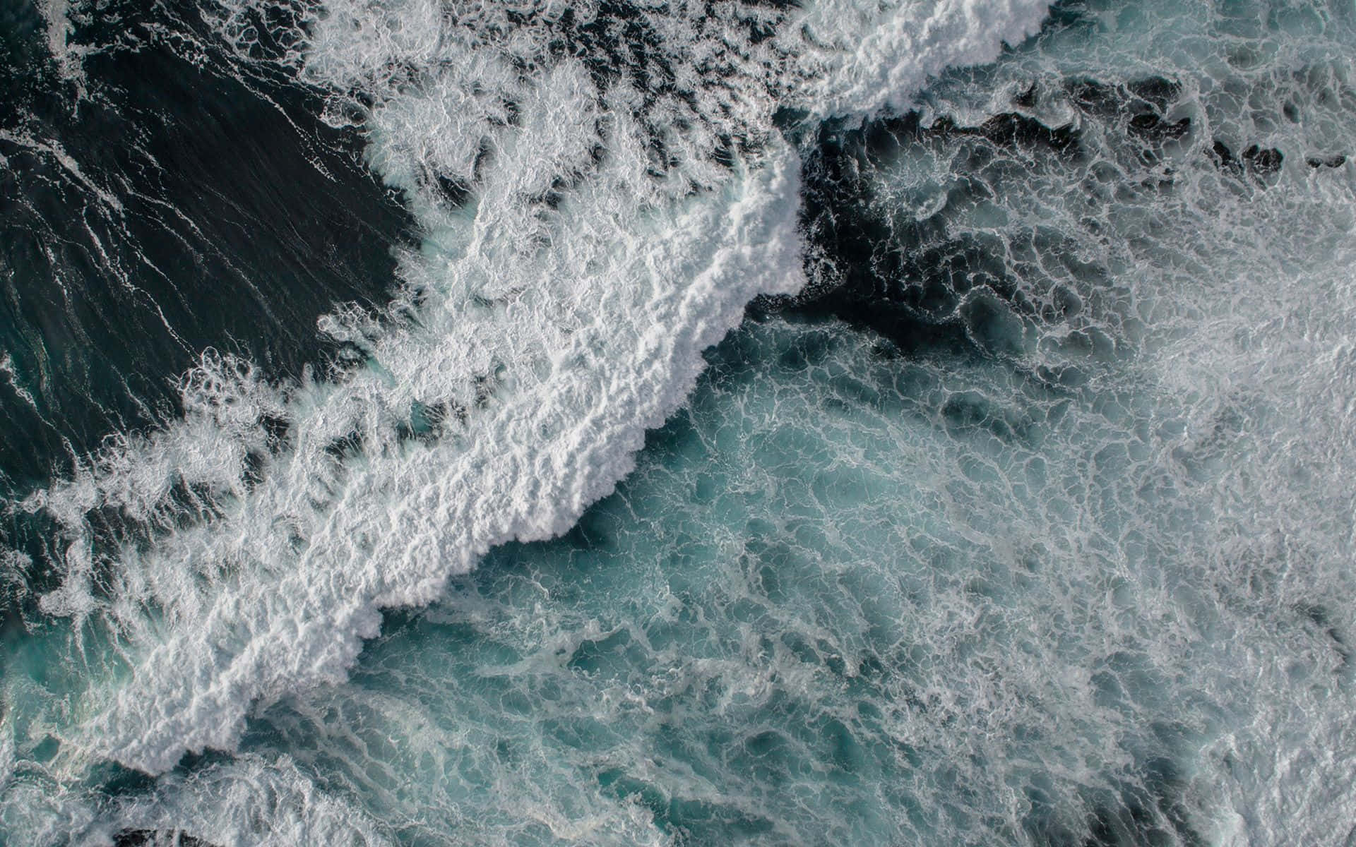 海浪 桌布 壁紙 — 從空中俯瞰洶湧的海浪，白色泡沫拍打著深藍綠色和黑色的海水。