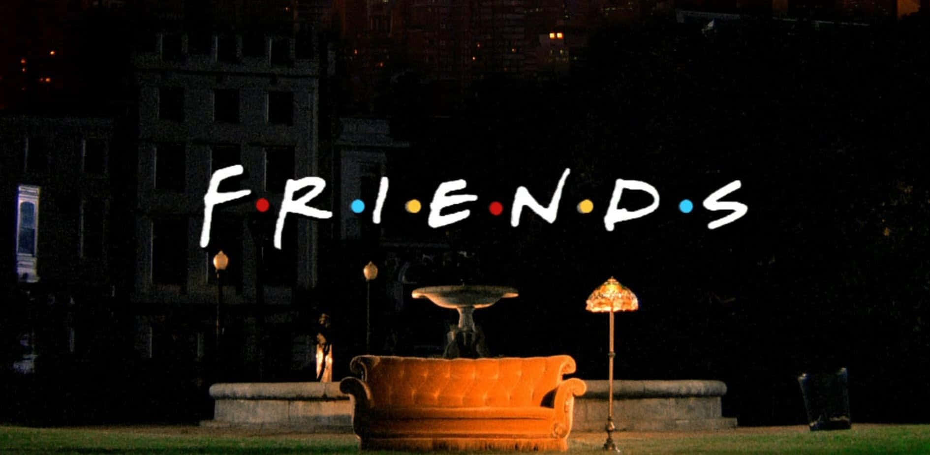 夜晚公園中的橙色沙發，後面有 'FRIENDS' 標誌和城市燈光。