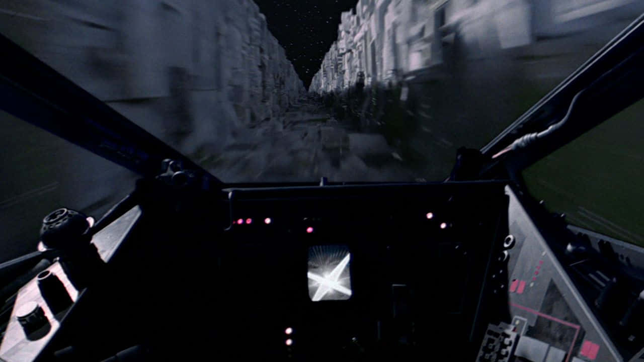 The Trench Run 桌布 壁紙 — 從駕駛艙內部第一人稱視角，在夜間高速穿越狹窄峽谷，發光的儀表板。