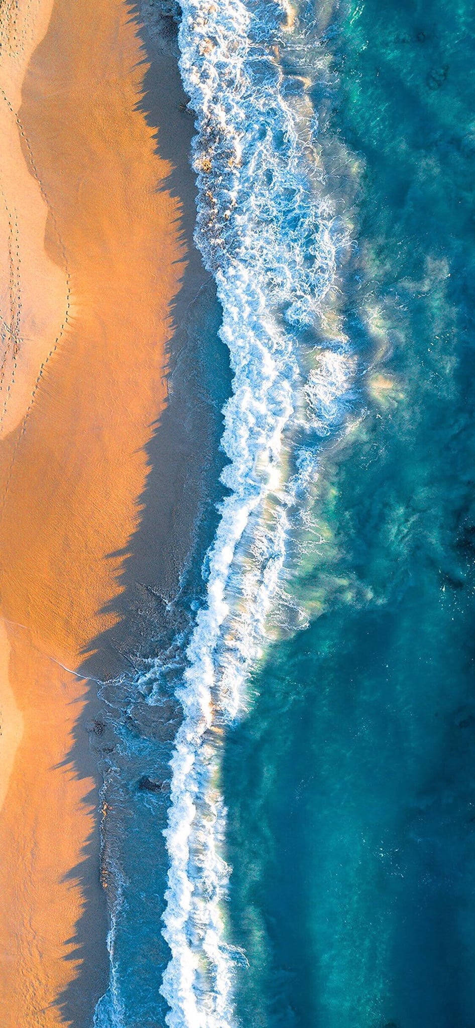 Wave 桌布 壁紙 — 從高空俯瞰，碧綠色的海浪拍打著金色沙灘，清晰的陰影勾勒出海岸線。
