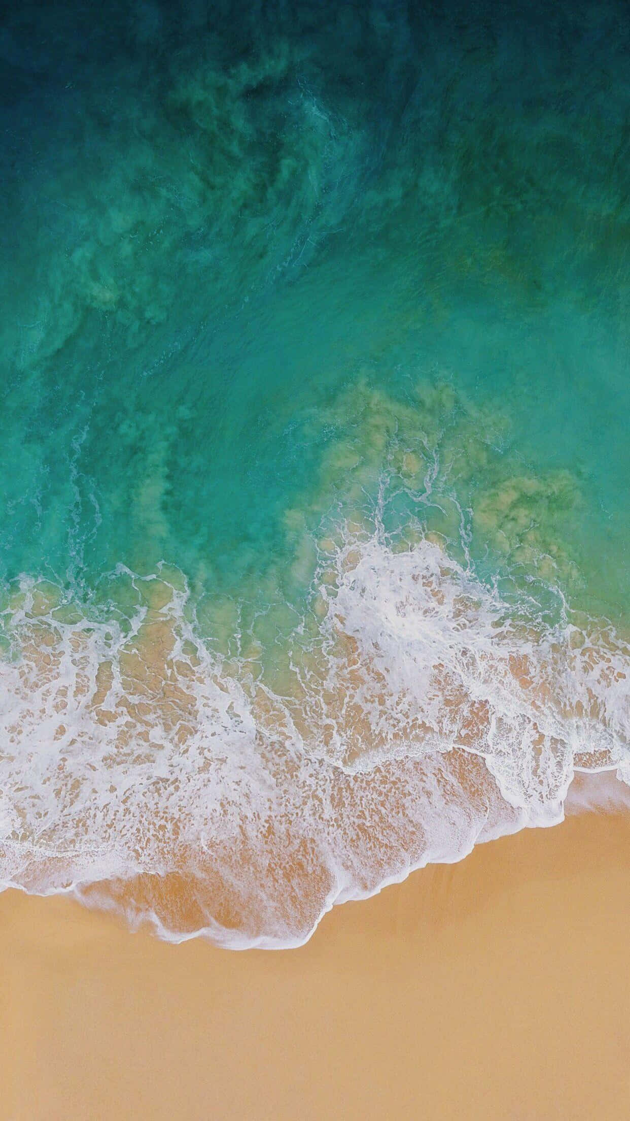 iPad pro 桌布 壁紙 — 從高空俯瞰，碧綠色的海浪拍打著金色沙灘，泛起白色泡沫。
