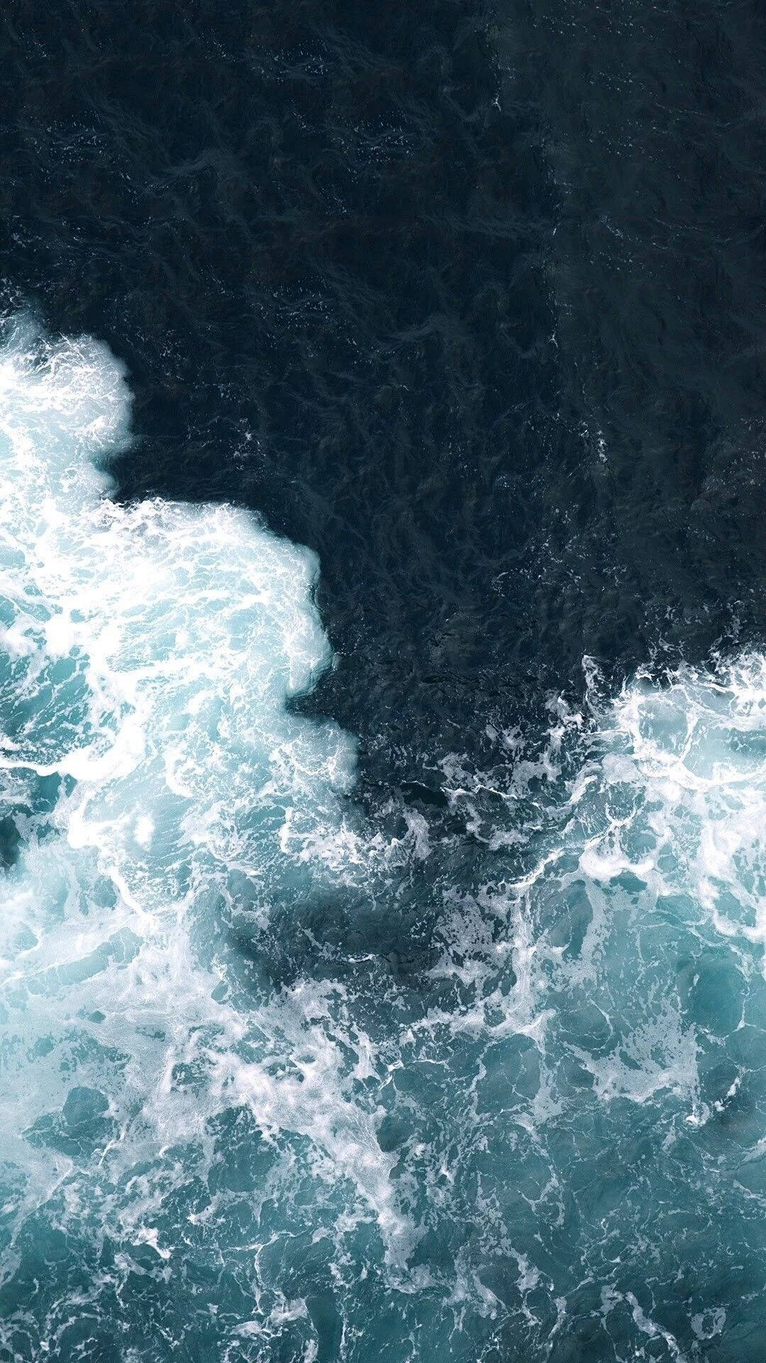 海洋 桌布 壁紙 — 從高空俯瞰洶湧的海浪拍打著深藍綠色和深藍色海水，激起白色泡沫。