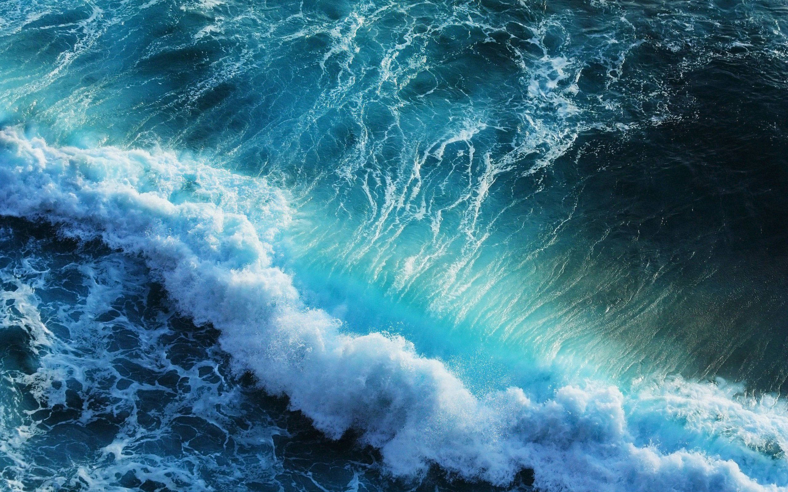 海洋 桌布 壁紙 — 從高空俯瞰洶湧的海浪拍打著深藍色海水，激起白色泡沫。