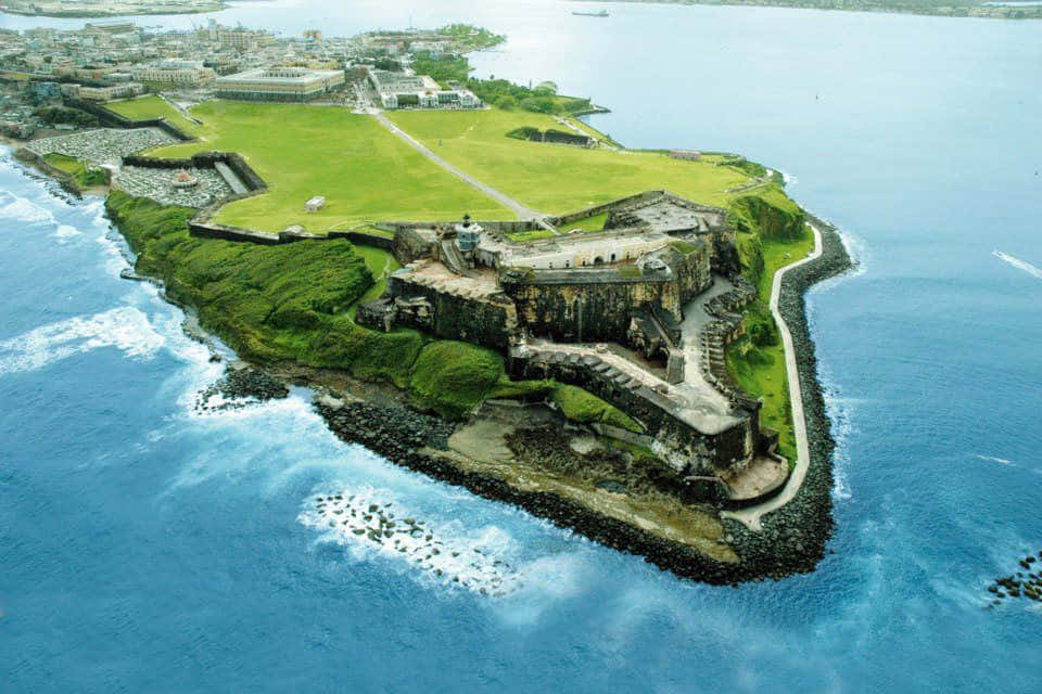 古老石堡壘位於綠色島嶼上，被藍色海洋波浪環繞。