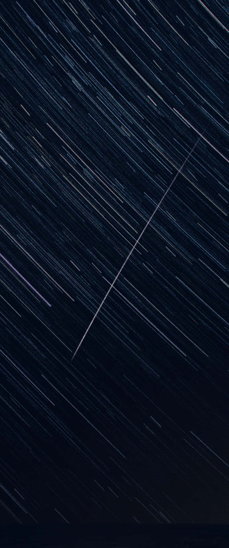 星軌在長時間曝光照片中對角線橫跨黑暗夜空。