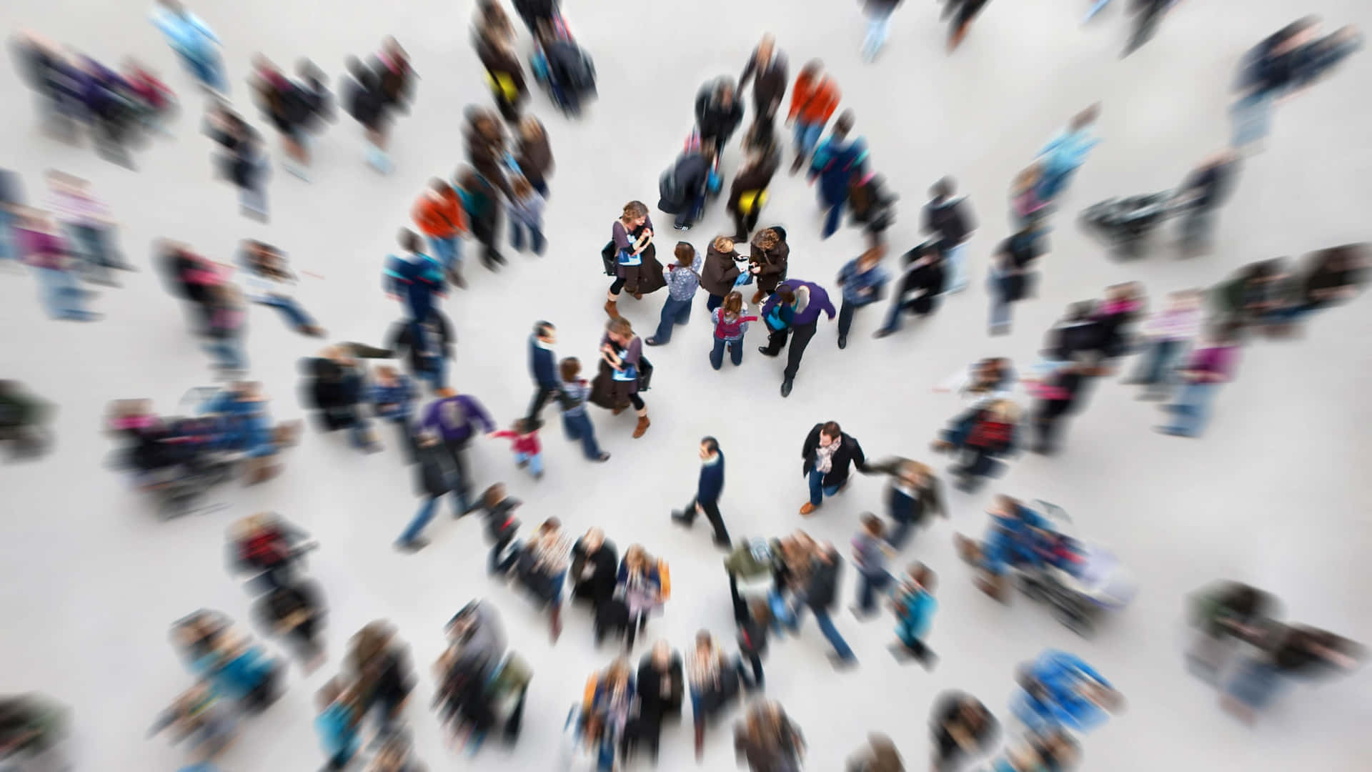 People 桌布 壁紙 — 從高角度拍攝的模糊照片，人群在明亮的白色地板上以圓形圖案移動。