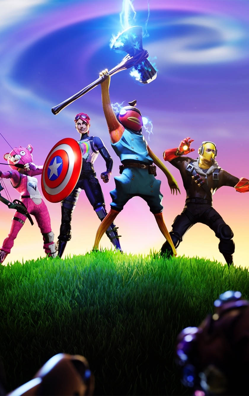 四個 Fortnite 角色英雄式地在長滿草的山丘上擺姿勢，手持發光武器。